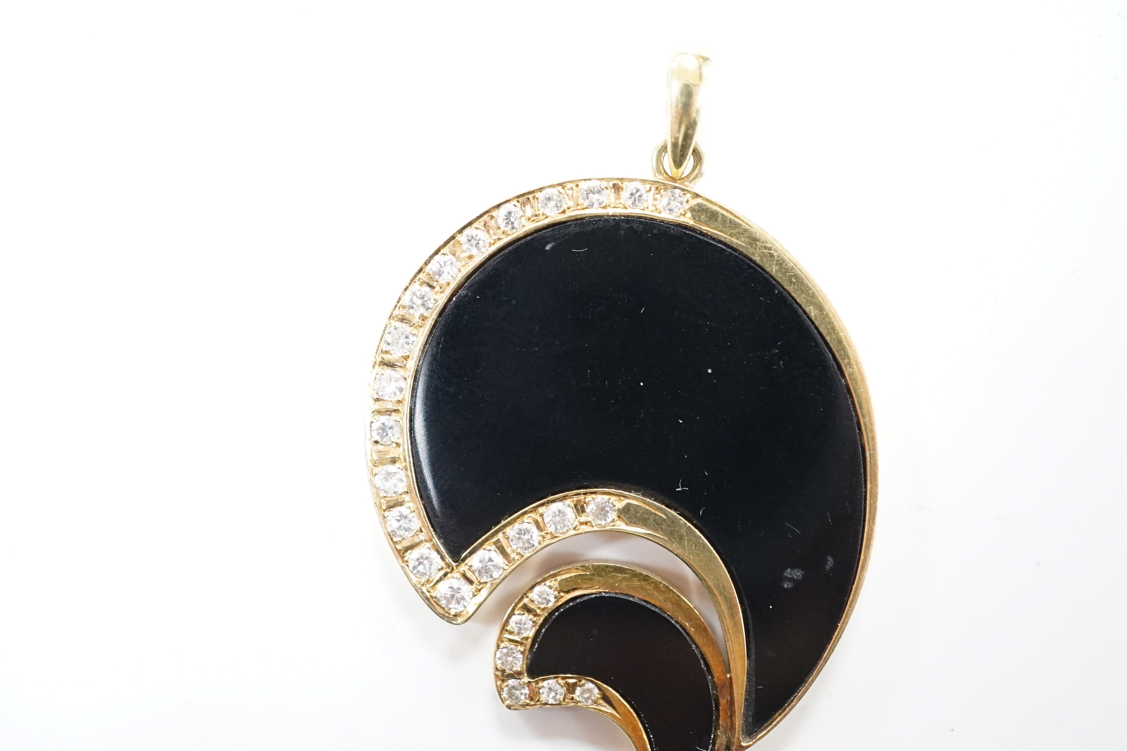 A Hong Kong 585 yellow metal, black onyx and diamond set stylised pendant, 43mm, gross weight 12.1 grams.